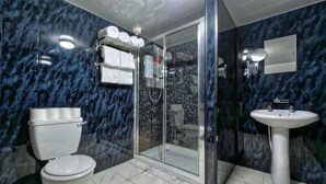 A bathroom with a toilet, a shower with glass doors, and a sink. - The Grainger Hotel (Newcastle-upon-Tyne)