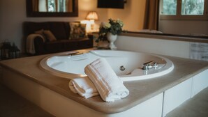 Ein Badezimmer mit einer großen Badewanne, einem Waschbecken und einem Handtuch auf der Ablagefläche.
