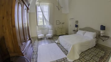 Ein Schlafzimmer mit einem großen Bett, einem Holzschrank, einem Schreibtisch und einem Stuhl.