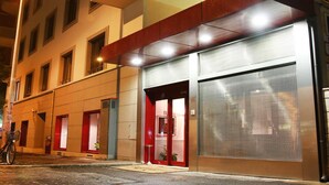 Un bâtiment à la façade moderne, doté de grandes fenêtres et d’une entrée rouge bien visible.