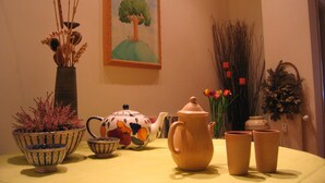 Ein Tisch mit Teekanne, Tassen, einer Schüssel und Zierpflanzen.
