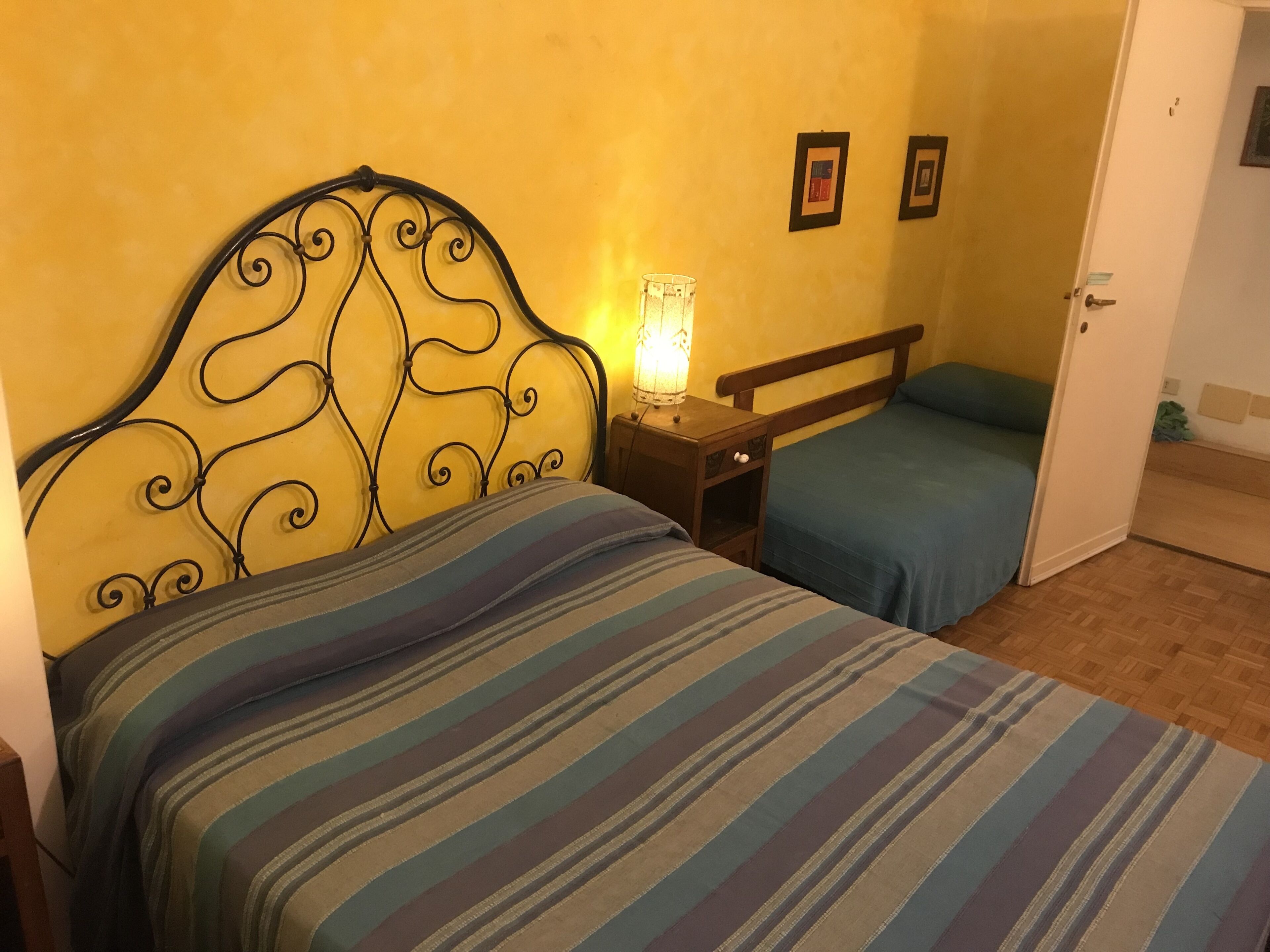 A room with a bed, a nightstand, and a door.