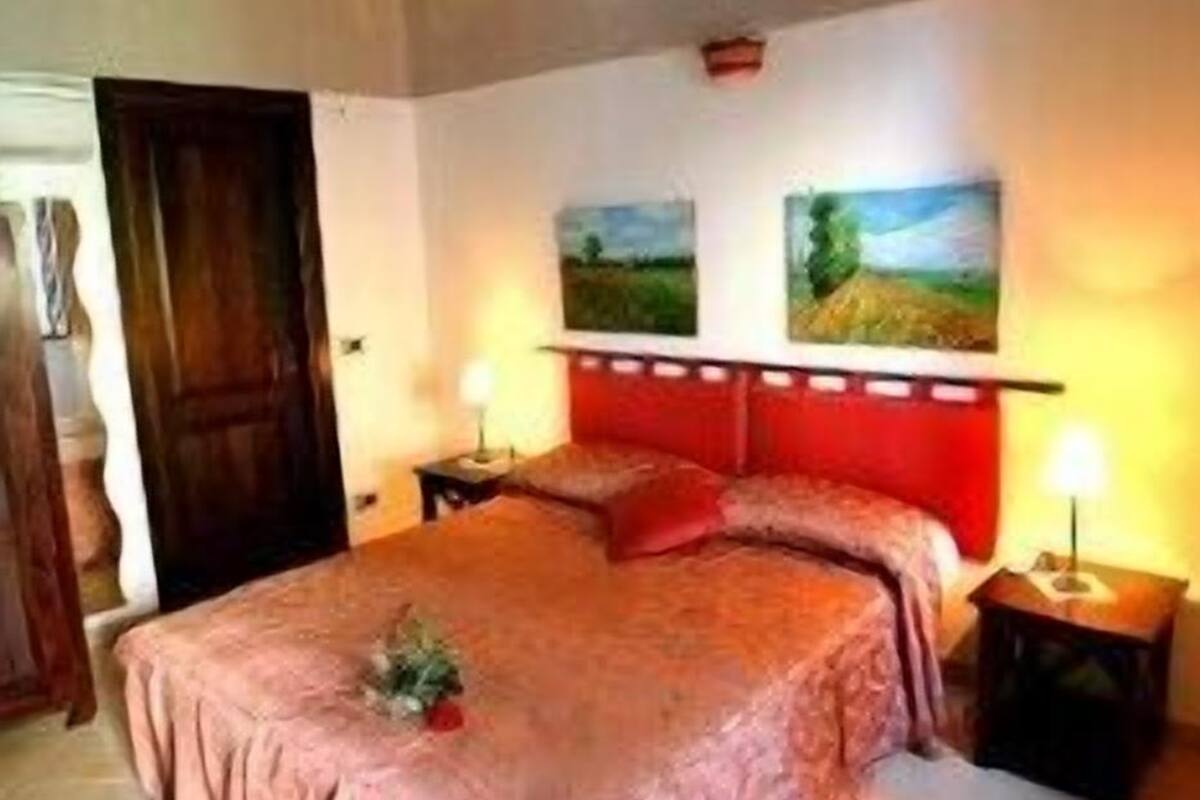 Ein Schlafzimmer mit einem großen Bett, zwei Nachttischen und zwei Wandlampen.