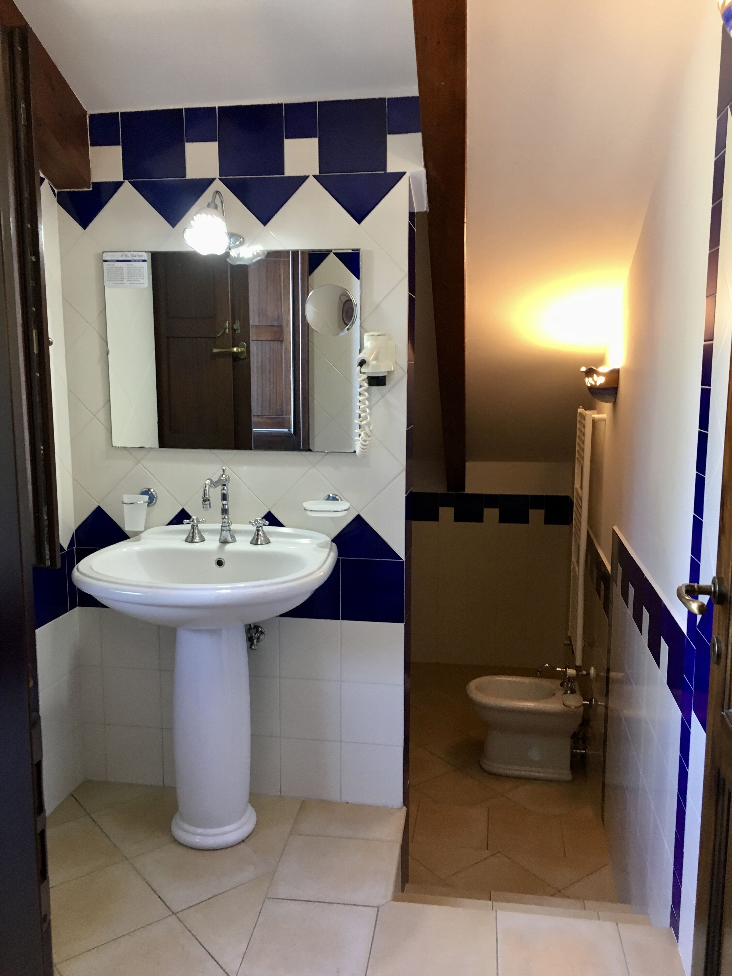 A bathroom with a white sink, a mirror, and a bidet.