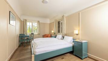 A bedroom with a bed, a desk, and a chair.