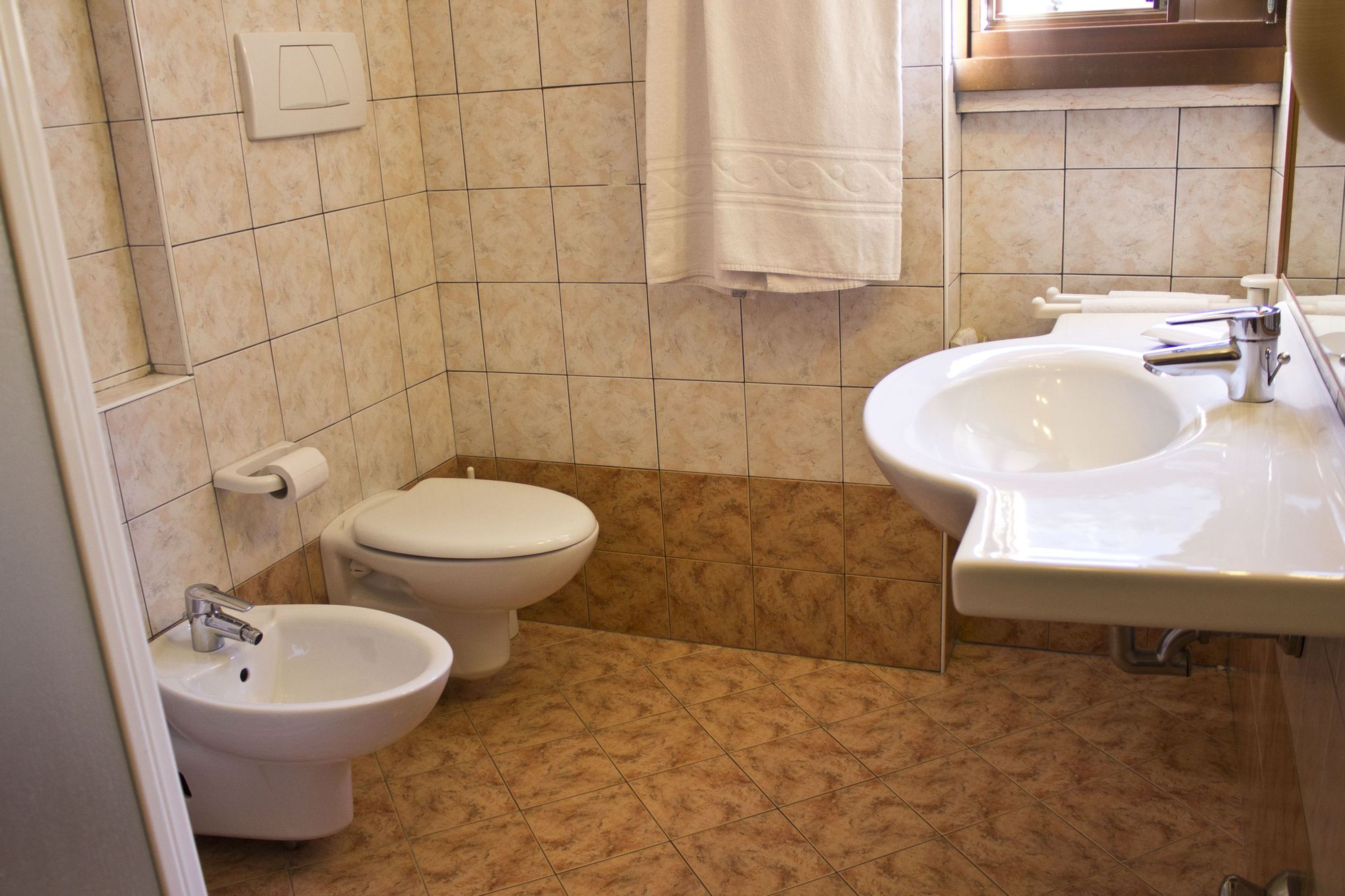 A bathroom with a toilet, bidet, and sink.