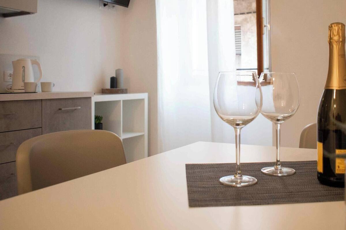 A dining table with two wine glasses and a bottle of champagne.