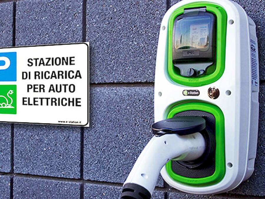 Een oplaadstation voor elektrische voertuigen met een bord in Italiaans.