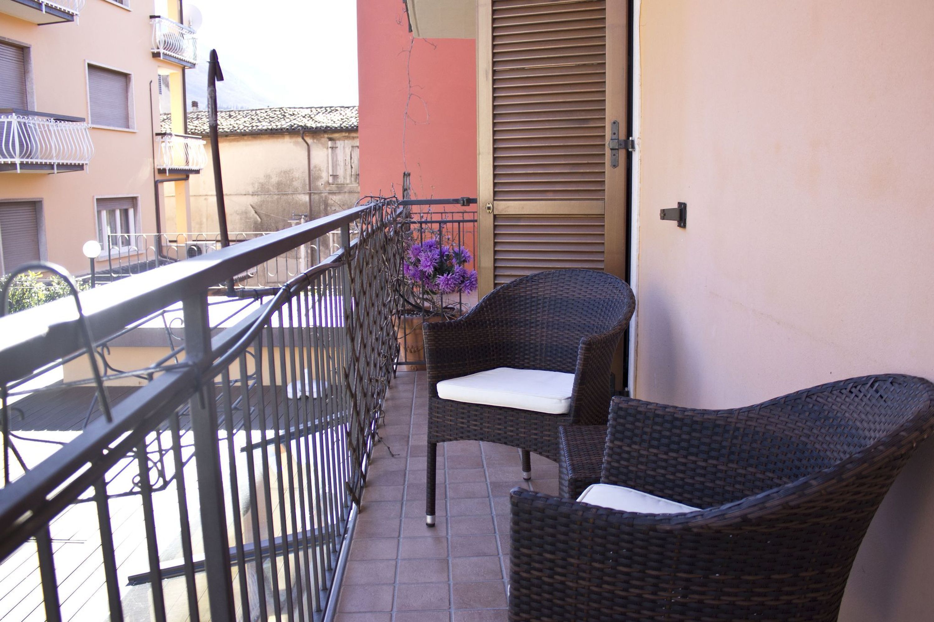 A balcony with wicker furniture and a potted plant.