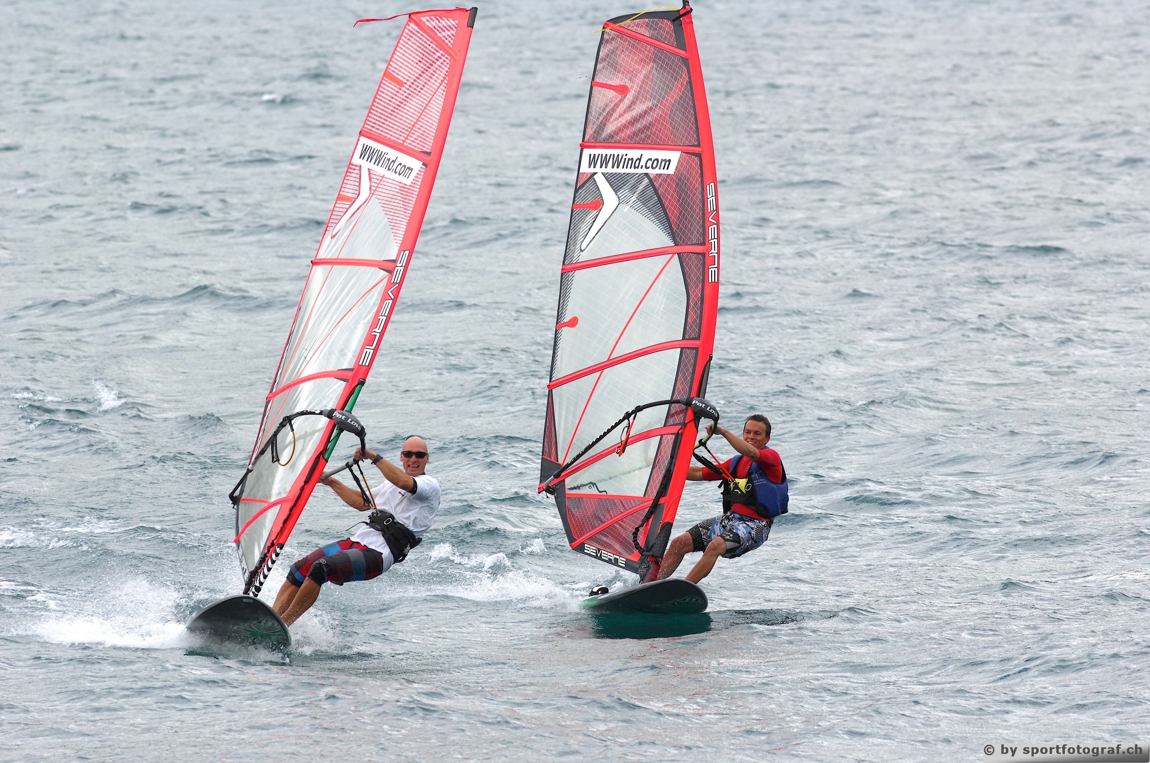 Two windsurfers on a body of water.