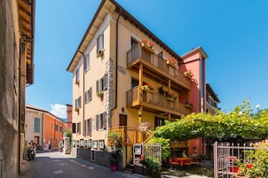Un hotel con balcón, mobiliario exterior y un letrero que indica que es un hotel.