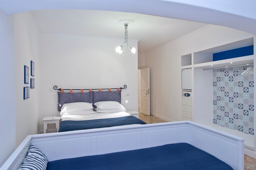 A bedroom with a bed, nightstand, and a wardrobe.