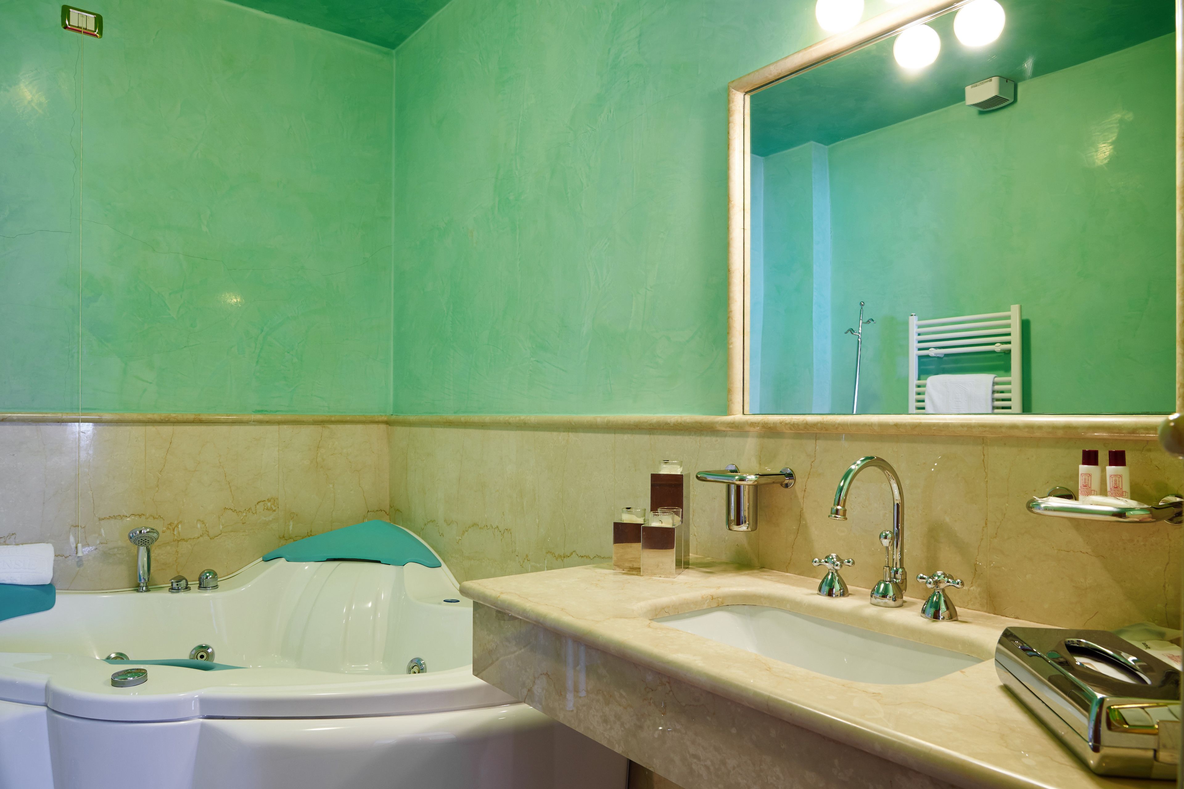 Ein Badezimmer mit einer Badewanne, einem Waschbecken und einem Spiegel.