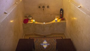 A bathroom with a bathtub, candles, and a towel rack.