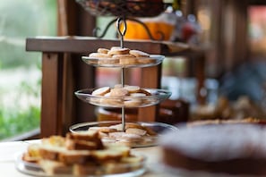 A three-tiered glass stand with cookies and slices of bread. - Fattoria Voltrona (San Gimignano)