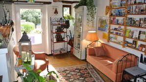 Una sala acogedora con un sofá, una mesita, una estantería y una puerta que da al exterior.