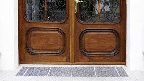 A wooden double door with intricate ironwork and a glass panel. - Villa Ceconi by Das Grüne Hotel zur Post (Salzburg)