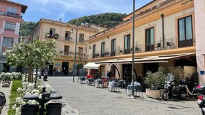 A street with outdoor seating, a tree, and parked motorcycles. - Blurooms (Sorrento)