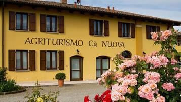 A yellow building with the sign "AGRITURISMO Cà Nuova".