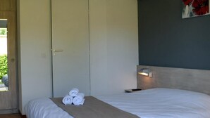 Une chambre d’hôtel avec un lit, une porte, un appareil de climatisation et un tableau au mur.