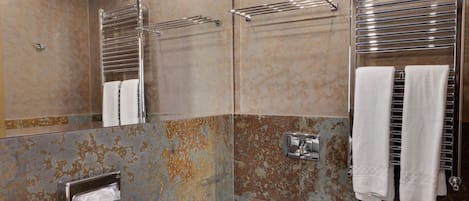 A modern bathroom with a large sink, two urinals, and a mirror.
