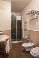 Un bagno con doccia, bidet, lavandino e WC.