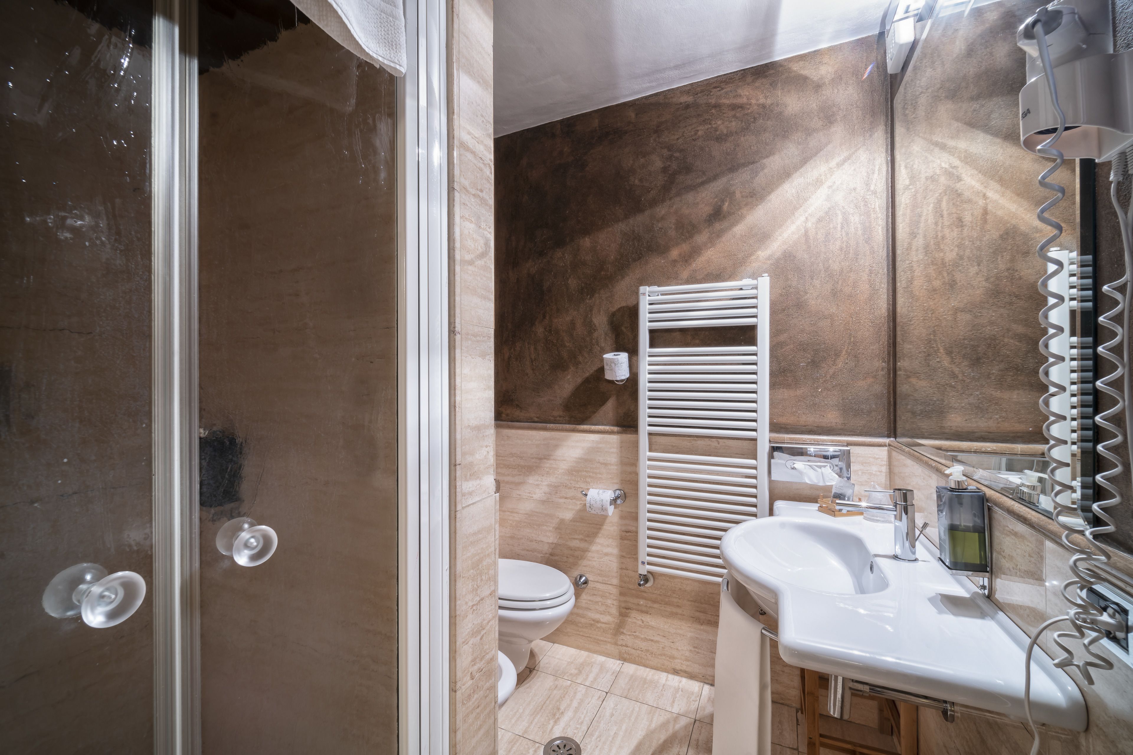 A bathroom with a shower, toilet, and sink.