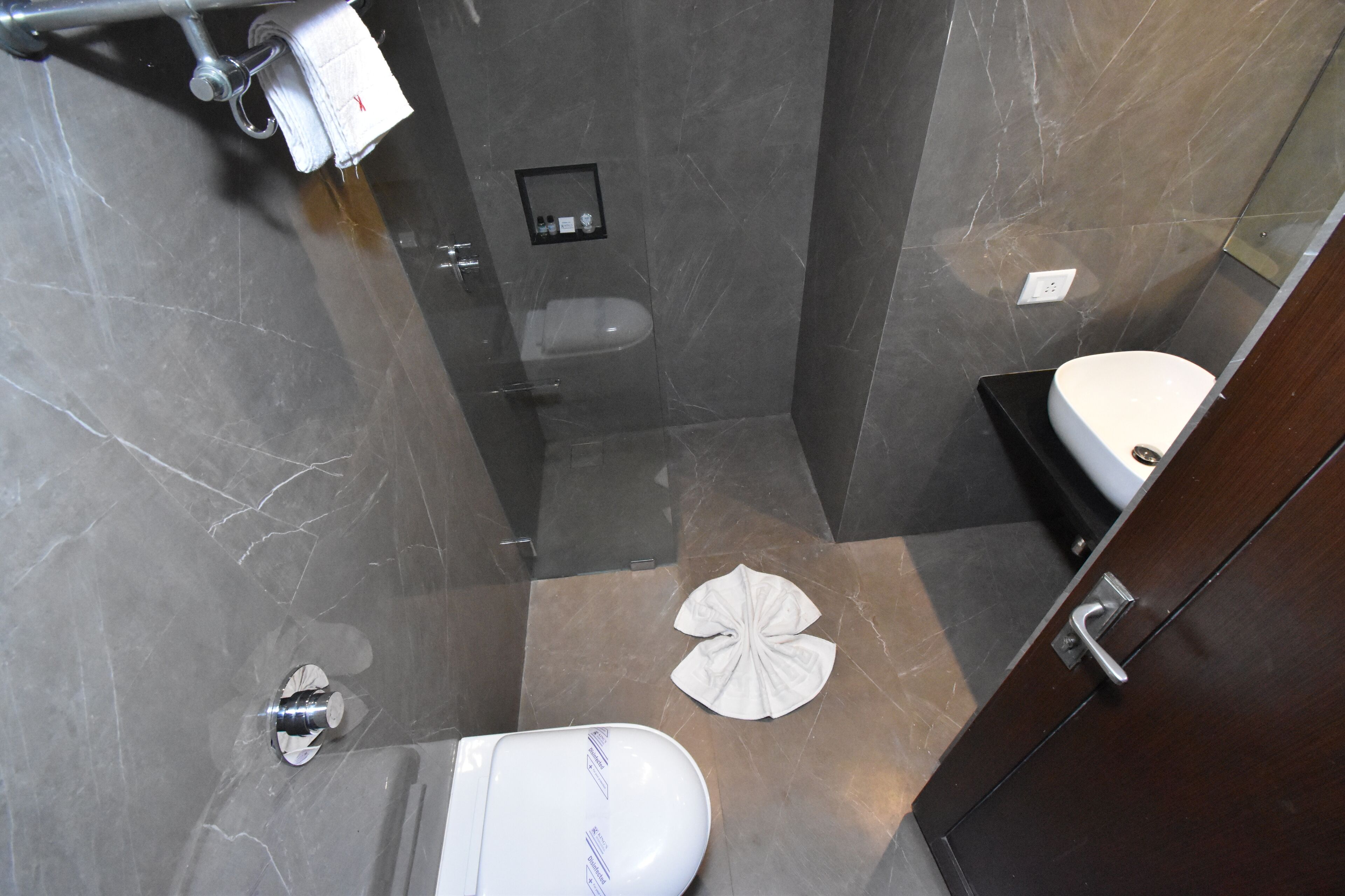 A bathroom with a toilet, a shower, and a sink.
