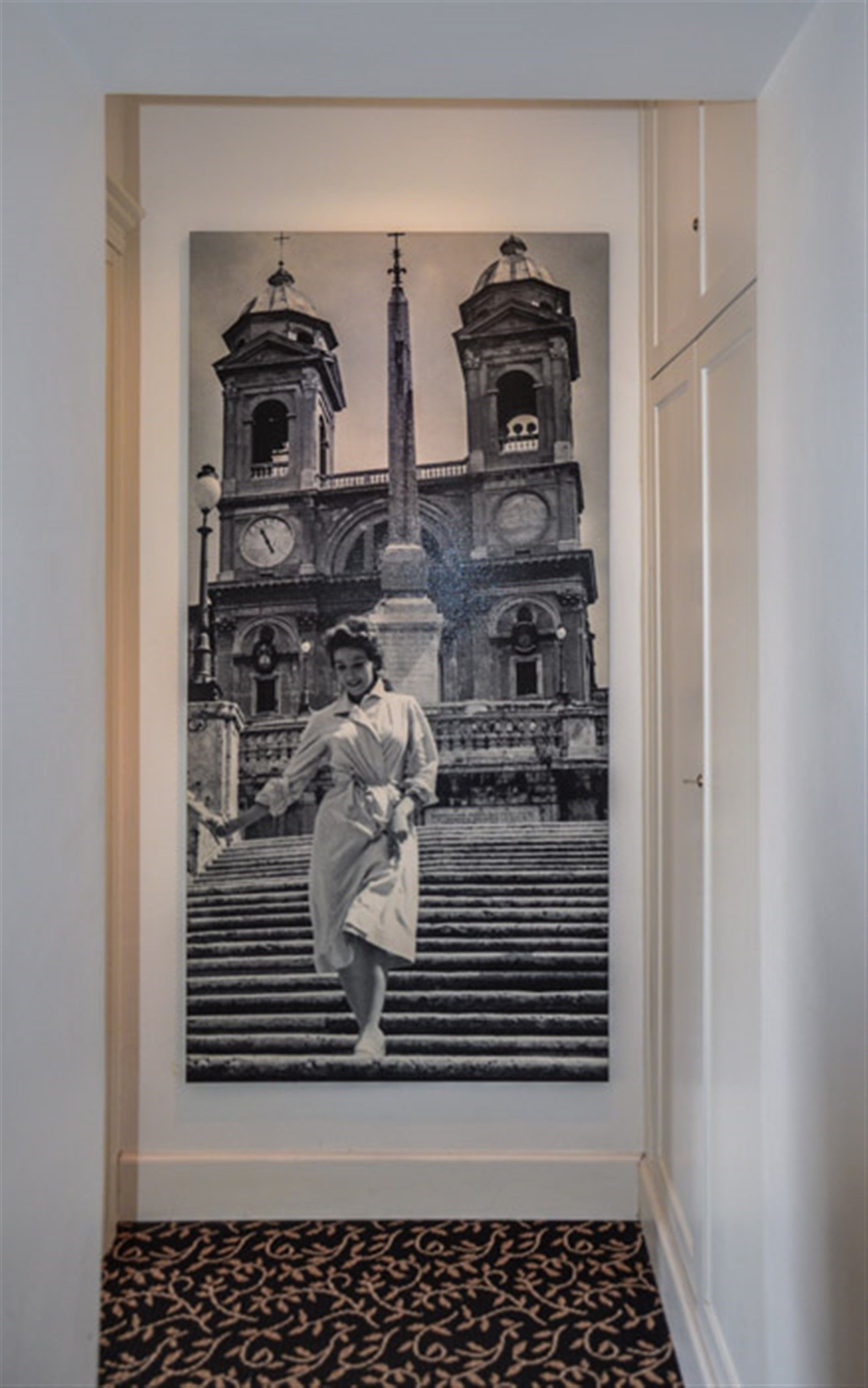 A photograph of a person standing on a staircase with a historical building in the background.