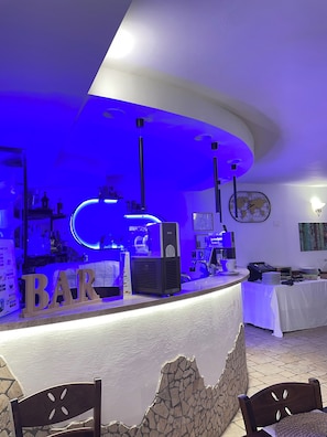 A bar area with a counter, bar stools, and a world map on the wall. - Albergo Pace (Pompei)