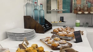 A buffet table with pastries, condiments, and a sign indicating 'CORNETTI' and 'VUOTTI.' - Albergo Pace (Pompei)