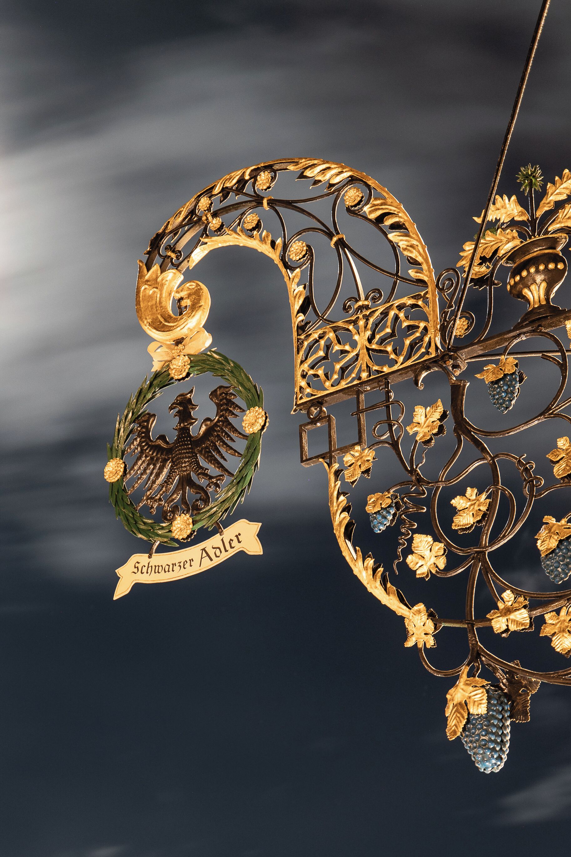 Adorno metálico decorativo con un adorno de laurel y un emblema de águila, que incluye la inscripción "Schmarscher Adler".
