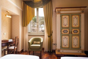 Una habitación con una cama, un escritorio con libros, una silla, un armario y una ventana con cortinas.