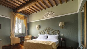A hotel room with a bed, a desk, a chair, and a window with curtains. - RELAIS PARCO DEI CAVALIERI ASSISI (Assisi)