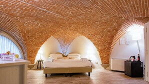 A bedroom with a brick ceiling, a bed, a desk, and a lamp. - N4U Guest House (Florence)