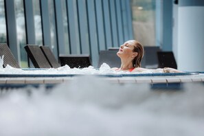 A person in a swimming pool with water splashing around them.