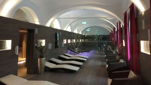 Een moderne spa met een lange, gebogen plafond en rijen comfortabele stoelen.