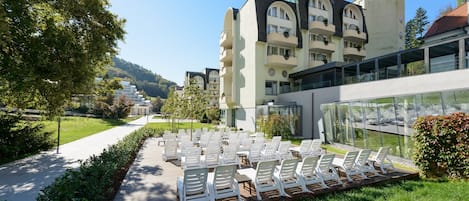 Un hotel moderno con zona de piscina, mobiliario exterior y vistas del paisaje circundante.