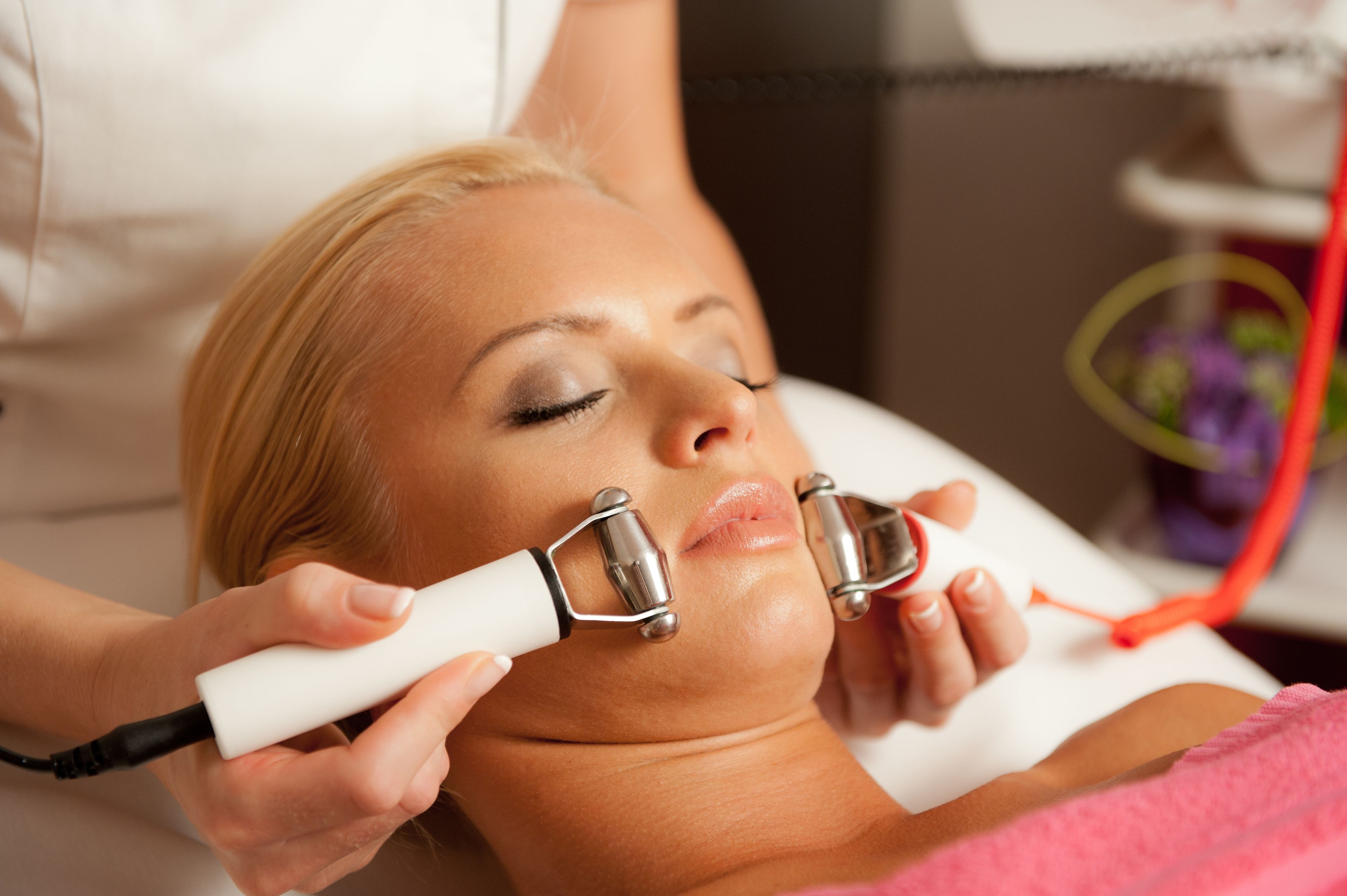 A person lying down with a medical device being used on their neck.