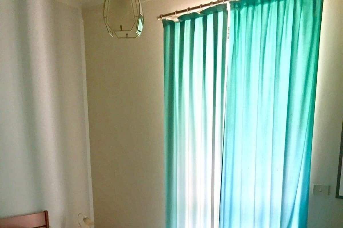A bedroom with a bed, a desk, and a chair.