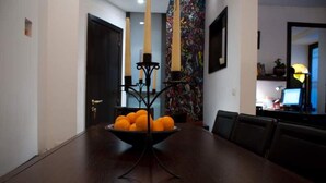 Una mesa de comedor con un candelabro negro y naranjas en el centro.