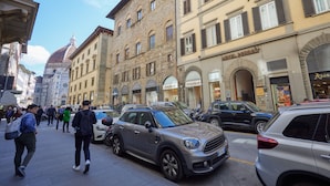 A street with parked cars and pedestrians. - Residenza Maglioni al Battistero (Florence)