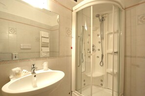 A bathroom with a glass-enclosed shower, a sink, and a mirror. - Hotel Le Ginestre (Roccacasale)