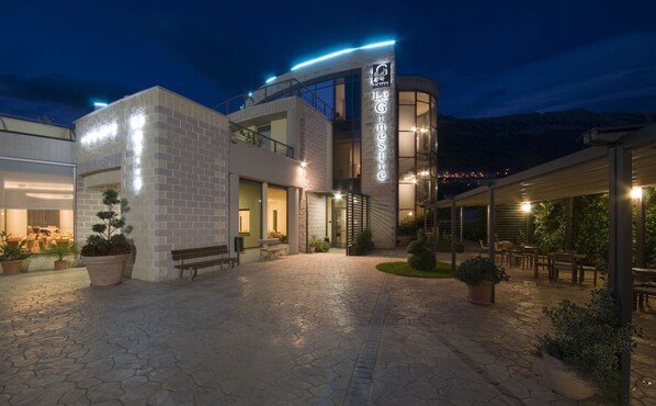 A hotel with a modern design, featuring a courtyard with seating and plants. - Hotel Le Ginestre (Roccacasale)