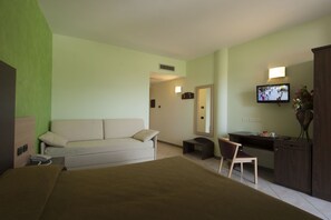 A hotel room with a bed, a sofa, a desk, and a television. - Hotel Le Ginestre (Roccacasale)