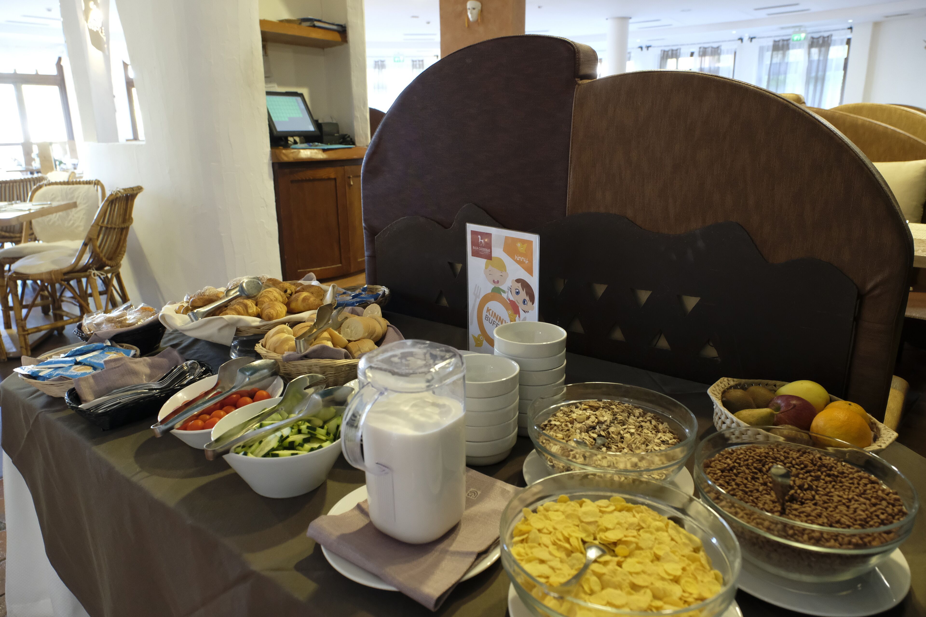 Una mesa de buffet con diferentes alimentos y una jarra de leche.