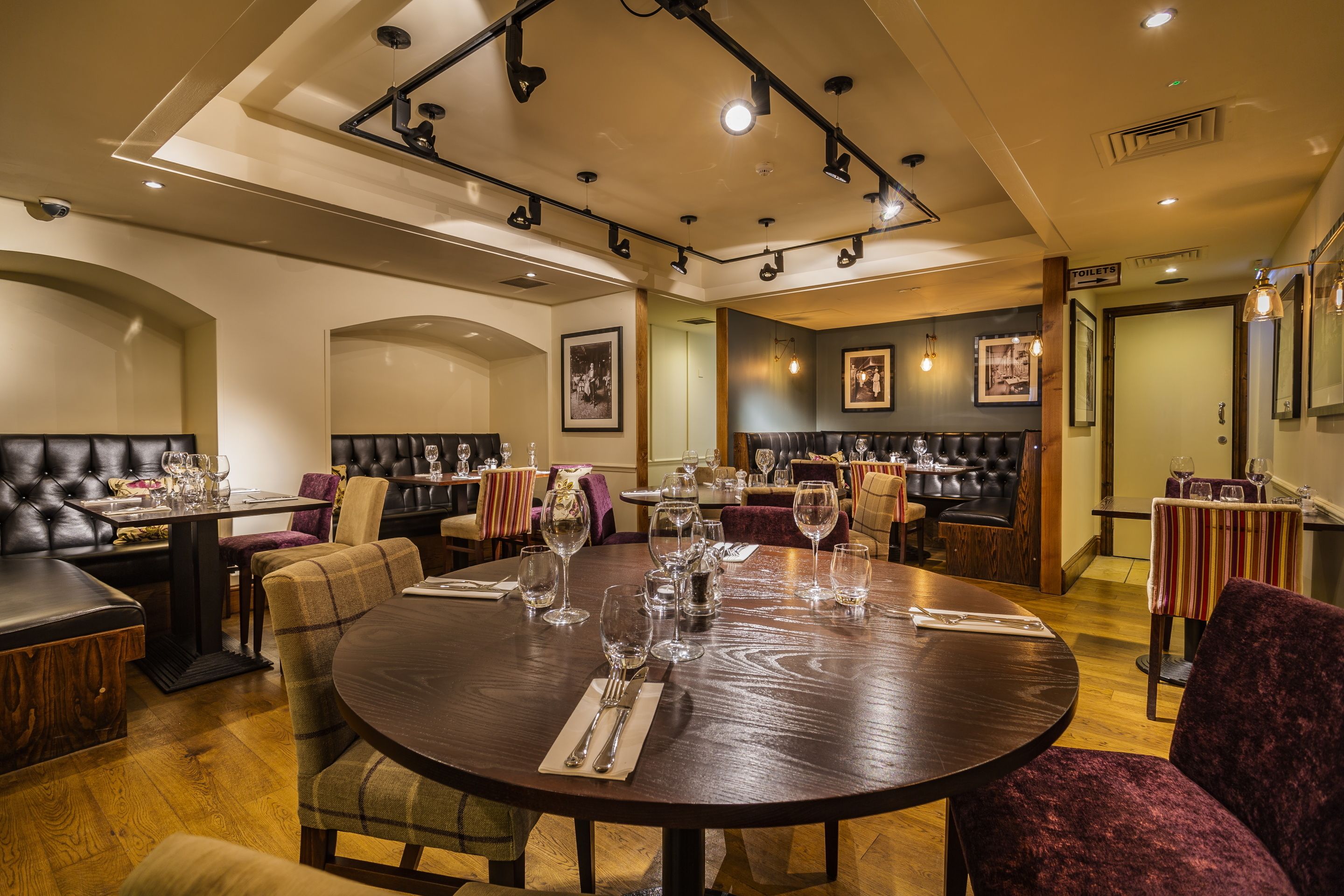 Ein Restaurant mit einem großen runden Tisch, mehreren Sitzgruppen und einer Bar.