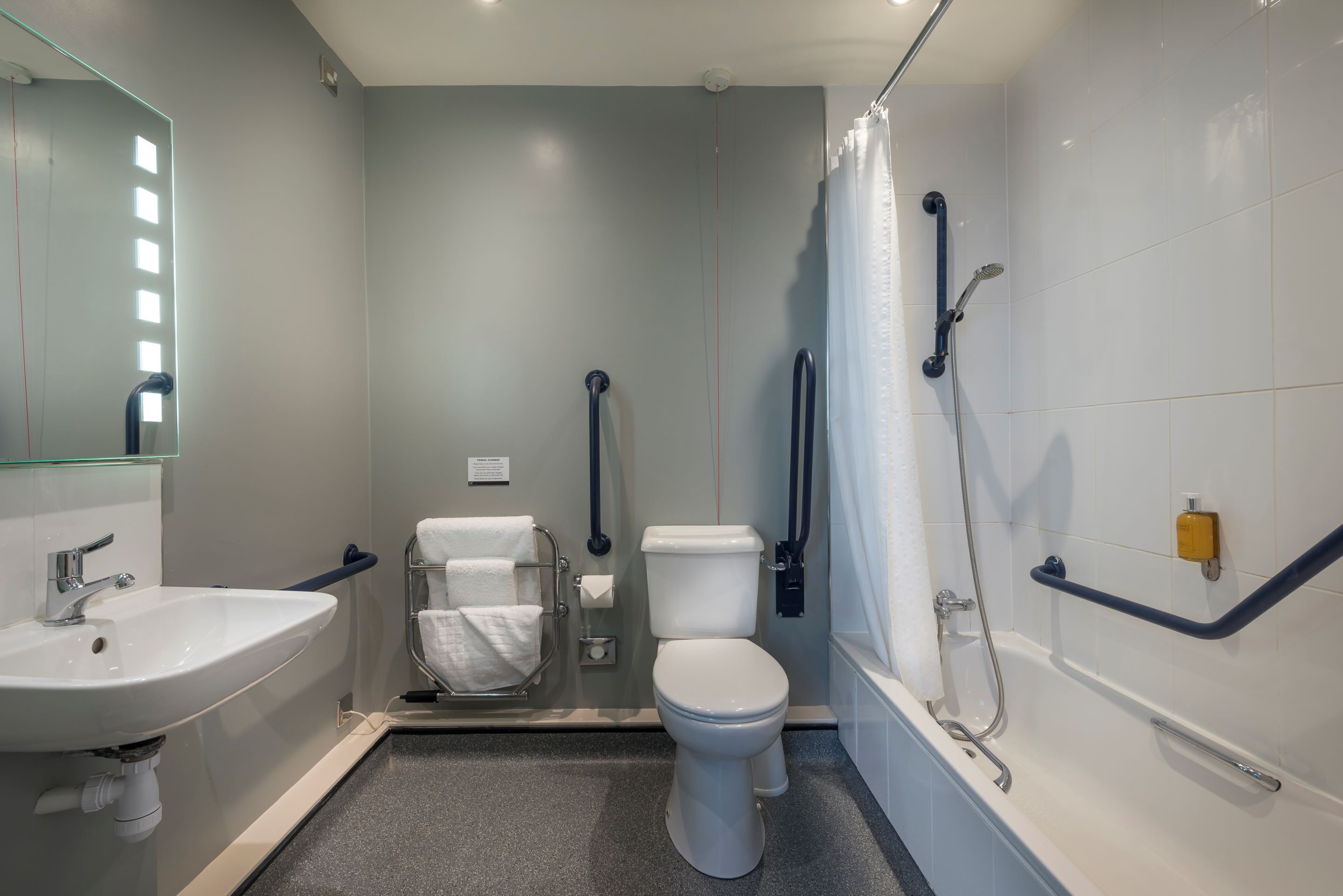 A modern bathroom with a sink, toilet, and shower.