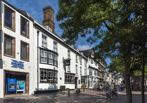 Un edificio blanco con un letrero que dice 'Halifax', un letrero que dice 'Swan Hotel' y un letrero que dice 'Theatre Royal'.