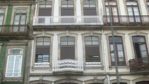 Een meerlaags gebouw in klassieke stijl, met versierde balkons en grote ramen.